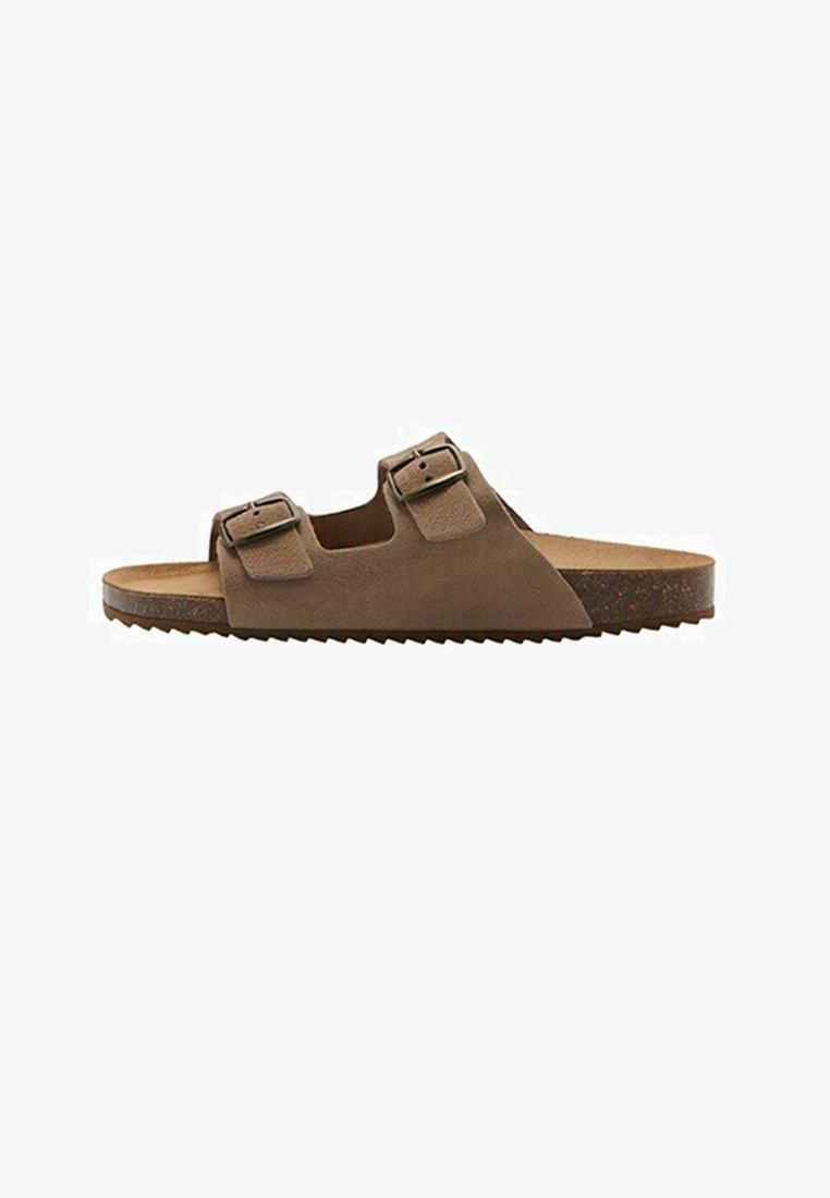 Brązowy sandał z odkrytymi palcami, z dwoma regulowanymi paskami zapinanymi na sprzączki oraz płaską korkową podeszwą z teksturowanym spodem.