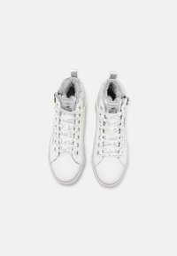 Baskets montantes blanches en cuir synthétique. Les caractéristiques comprennent une doublure en polaire grise, des lacets avec logo et une fermeture éclair sur le côté.
