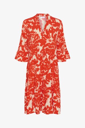 Robe à motifs rouge et crème avec un décolleté en V, des manches évasées et une jupe à volants. Fabriquée en tissu léger, arborant un design floral.