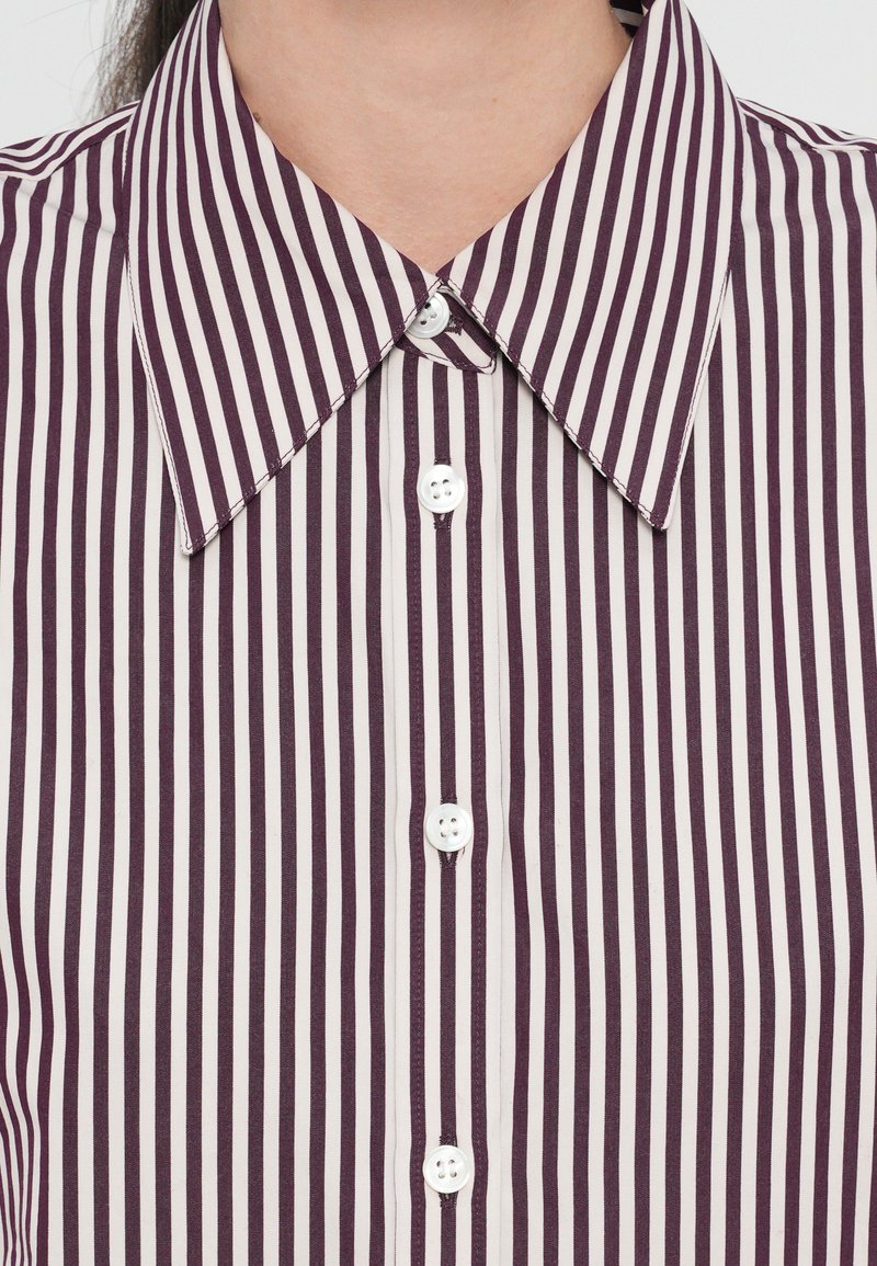 Camicia a righe con bottoni, caratterizzata da righe verticali bordeaux e bianche, colletto classico e bottoni bianchi, realizzata in tessuto morbido.