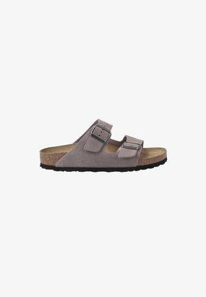 Suède slipper sandaal in lichtgrijs met twee verstelbare banden, metalen gespen, kurken voetbed en een zwarte rubberen loopzool voor grip.