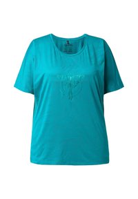 Camiseta de manga corta turquesa con cuello redondo, que presenta un sutil gráfico de mariposa y una textura suave y ligera.