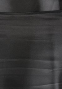 Čierna látková sukňa s hladkou textúrou, so subtílnym leskom a štruktúrovaným dizajnom. Bez viditeľných vzorov alebo ozdôb, rovnomerný vzhľad.