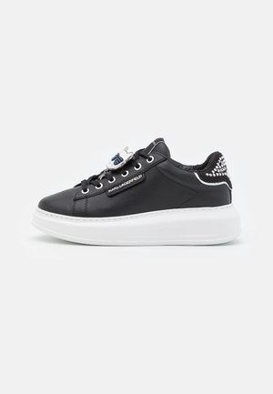 Czarny skórzany sneaker z białą grubą podeszwą, srebrną zawieszką na sznurowadłach oraz logo "Karl Lagerfeld" po boku i na tylnej części pięty.