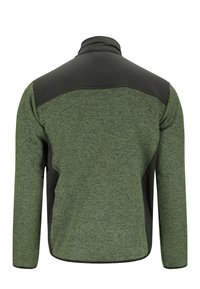 Set bagfra af grøn og sort langærmet jakke med høj krave og kontrasterende skulder- og sidepaneler.