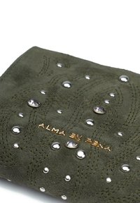 Oliwkowozielony portfel ze zamszu z wygrawerowanymi wzorami fal, ozdobnymi ćwiekami i złotym napisem, a także z kamieniami jubilerskimi, które podkreślają jego design.