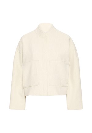 Veste courte crème en tissu texturé, col montant et deux grandes poches avant. Design carré avec manches larges.