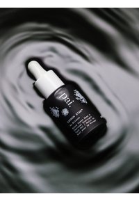 Svart glaskork med vit pipettkork, märkt "Carbon Star," har minimalistiska svart- och vitdesigninslag.