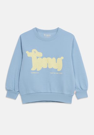 Sweat-shirt bleu clair pour enfant avec texte graphique crème "Tiny" en forme de chien, présentant les slogans "Summer 26" et "Tiny to the Core".