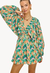 Vestido floral con un estampado en verde, rosa y naranja. Presenta mangas abullonadas, un escote en V profundo y una cintura recogida para un ajuste holgado.