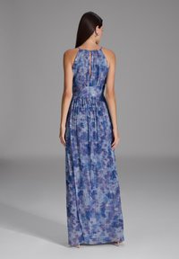 Vestido maxi en tonos azules con un diseño texturizado y plisado. Presenta un escote en forma de lágrima en la espalda y tirantes finos para una silueta elegante.