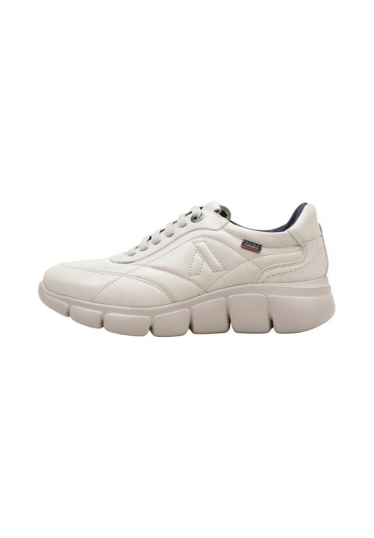 Zapatillas de color crema con parte superior de cuero texturizado, cuello acolchado y suela de goma gruesa y segmentada. Presentan un logo en el lateral.