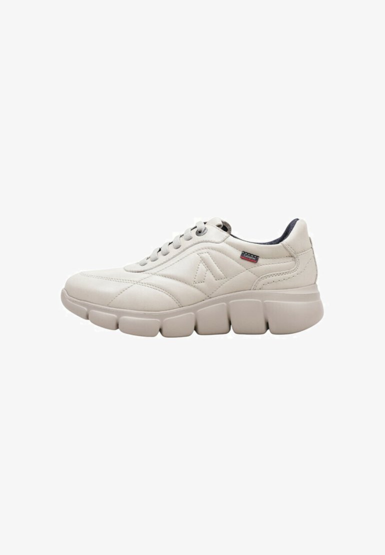 Zapatillas de color crema con parte superior de cuero texturizado, cuello acolchado y suela de goma gruesa y segmentada. Presentan un logo en el lateral.