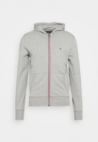 Sudadera con cremallera gris, con un bolsillo frontal, ribetes en rojo y blanco en la cremallera, y una textura suave. Cuenta con capucha y puños acanalados.