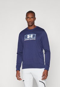 Navyblaues langärmliges Sweatshirt aus weichem Material mit einem zentralen Under Armour-Logo-Design, gerippten Bündchen und einem runden Halsausschnitt.