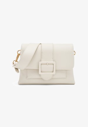 Crèmekleurige leren crossbodytas met brede riem, grote vierkante gesp op de voorsluiting en gouden metalen gespen aan de zijkanten.