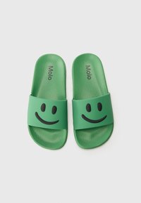 Zöld slip-on szandálok texturált felülettel, fekete mosolygós arc mintákkal a pántokon és "Molo" logóval a tetején.