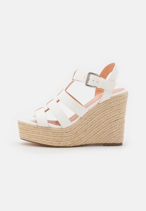 Sandalias blancas de cuña con tres correas horizontales, detalle de hebilla y suela de yute trenzado, con parte superior sólida y plataforma texturizada.