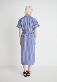 Gestreepte jurk in blauw-wit stof, met korte mouwen, een getailleerde taille en midi-lengte. Gladde textuur met een overhemdkraag en knoopsluiting.