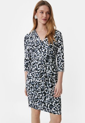 Robe à motifs abstraits en noir et blanc, avec un design enveloppant, un décolleté en V, des manches trois-quarts et une silhouette ajustée.