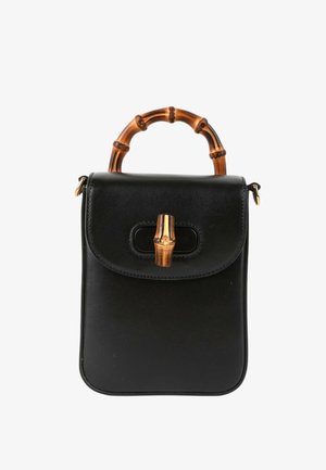 Kleine zwarte lederen handtas met bamboe-stijl gebogen handvat en bijpassende bamboe-stijl sluiting op de voorflap.