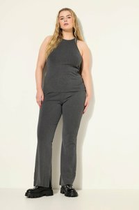 Harmaa ribbed-toppi ja yhdistelemättömät leveälahkeiset housut, pehmeästä materiaalista, joissa on sivurei'itykset, tyylillä mustat platform-kengät.