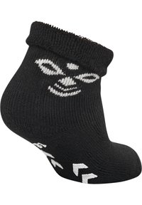 Svart ankelsocka med ribbad mudd, som har en vit grafisk design och ett texturerat mönster på sulan för bättre grepp.