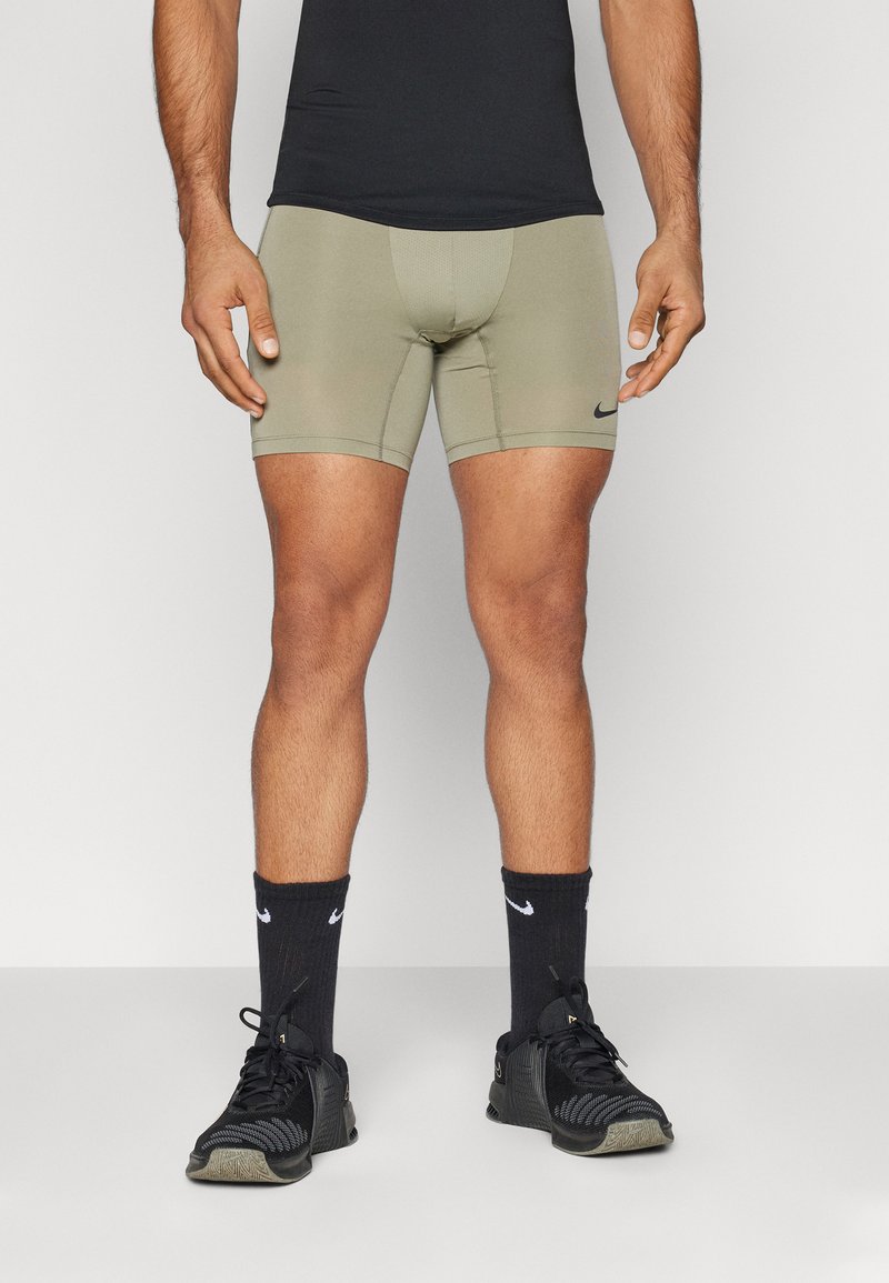 Kaki värvi sportlikud lühikesed püksid vormitud lõikega, millel on Nike logo. Kandmisel mustad sokid ja mustad spordijalanõud. Sile tekstuur.