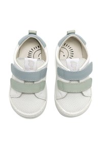Zapatos blancos con textura perforada, que presentan correas de Velcro en azul claro y color menta. Diseño de punta redondeada y plantilla acolchada.
