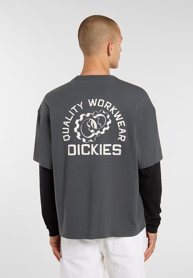 Gray short-sleeve t-shirt with a relaxed fit, featuring a white logo and gear graphic on the back, made from cotton material.