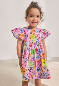 Vestito dai colori vivaci con faccine sorridenti, stelle e cuori. Realizzato in tessuto leggero con maniche svolazzanti e dettaglio di bottoni sul davanti.