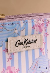 Mustriline kangast rahakott siniste ja valgete triipude, lillemotiivide ning elevandi illustratsiooniga. Omaduseks on tekstuuriga kuldne tõmblukk.