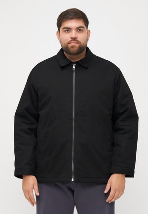 Black jacket with a zip front, collar, and two side pockets. It features a smooth texture and a relaxed fit with a slightly matte finish.
