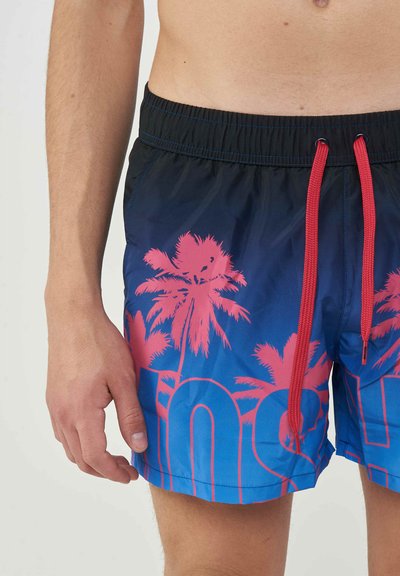 Male torso and legs wearing blue swim shorts with pink palm tree patterns and red drawstrings on elastic waistband.