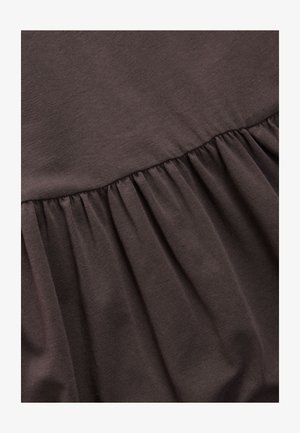 Tela marrón con un diseño fruncido en la parte inferior. El material parece suave y ligeramente texturizado, con una sección superior lisa.