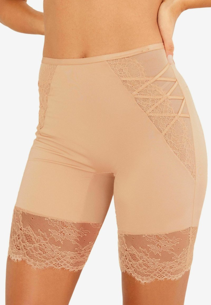 Beige shorts van rekbaar materiaal met kantaccenten aan de zijkanten en onderrand, met een kruisdetail.