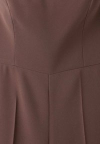 Vestido marrón ajustado hecho de una tela texturizada con un escote estructurado y una costura que corre verticalmente por el frente.