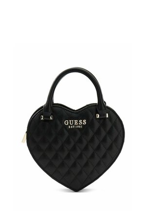 Sac à main en cuir noir matelassé en forme de cœur avec deux anses et logo argenté "GUESS EST 1981" sur le devant.