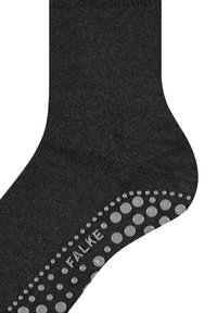 Černé ponožky z měkké látky mají na podrážce texturovaný vzor proti skluzu vyrobený ze silikonových teček, s výrazně viditelným logem „FALKE“.