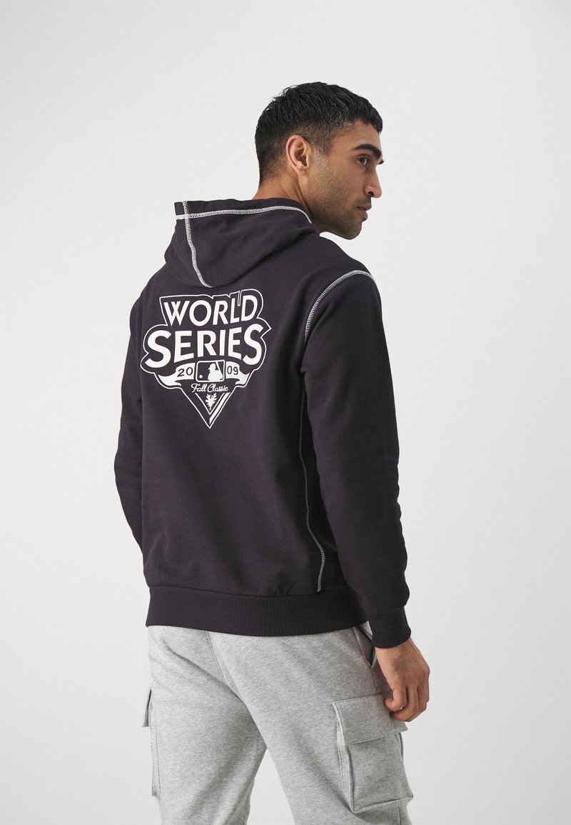 Sudadera negra con un gran logo blanco "WORLD SERIES 2009" en la parte de atrás. Presenta una capucha con cordón y ligeros detalles de costura.