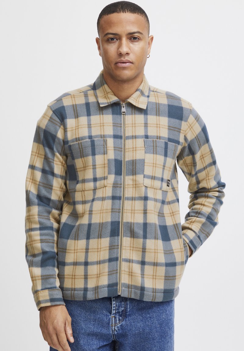 Flanelljacke in tannengrün, blau und cremefarbener Karomuster, mit einem Frontreißverschluss, zwei Brusttaschen und weicher Textur.
