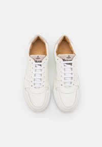 Bílé kožené tenisky Vivienne Westwood s bílými tkaničkami, béžovými polstrovanými límci a značkovými vložkami, zobrazené z vrchního pohledu na bílém pozadí.