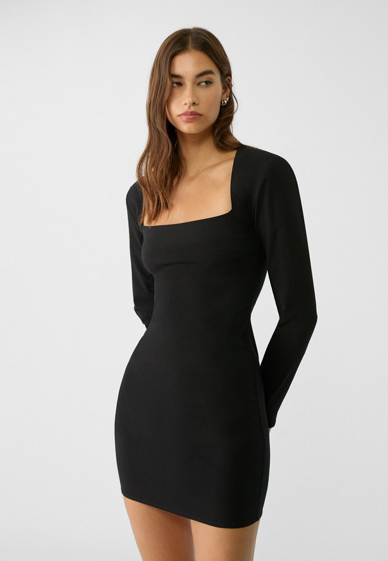 Schwarzes, langärmliges Minikleid mit quadratischem Ausschnitt, tailliertem Schnitt und glatter Textur. Schlichte Silhouette ohne zusätzliche Muster oder Akzente.