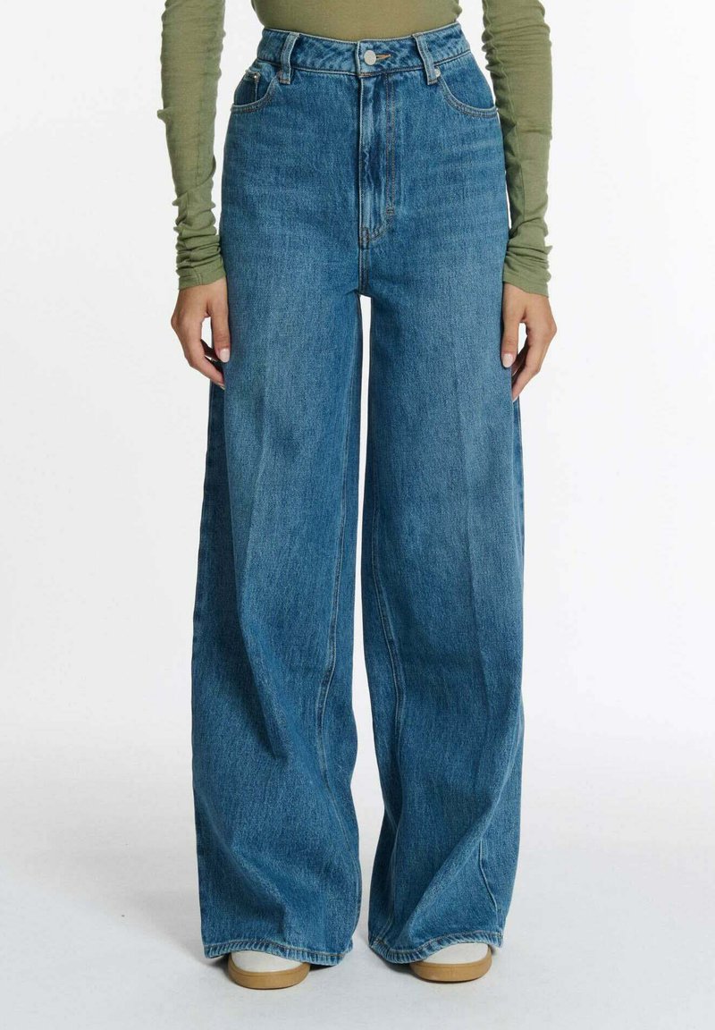 Hoge taille, wijde blauwe denim jeans met een reguliere pasvorm, voorzien van vijf zakken en een nette afwerking. Dik materiaal met subtiele wassing.