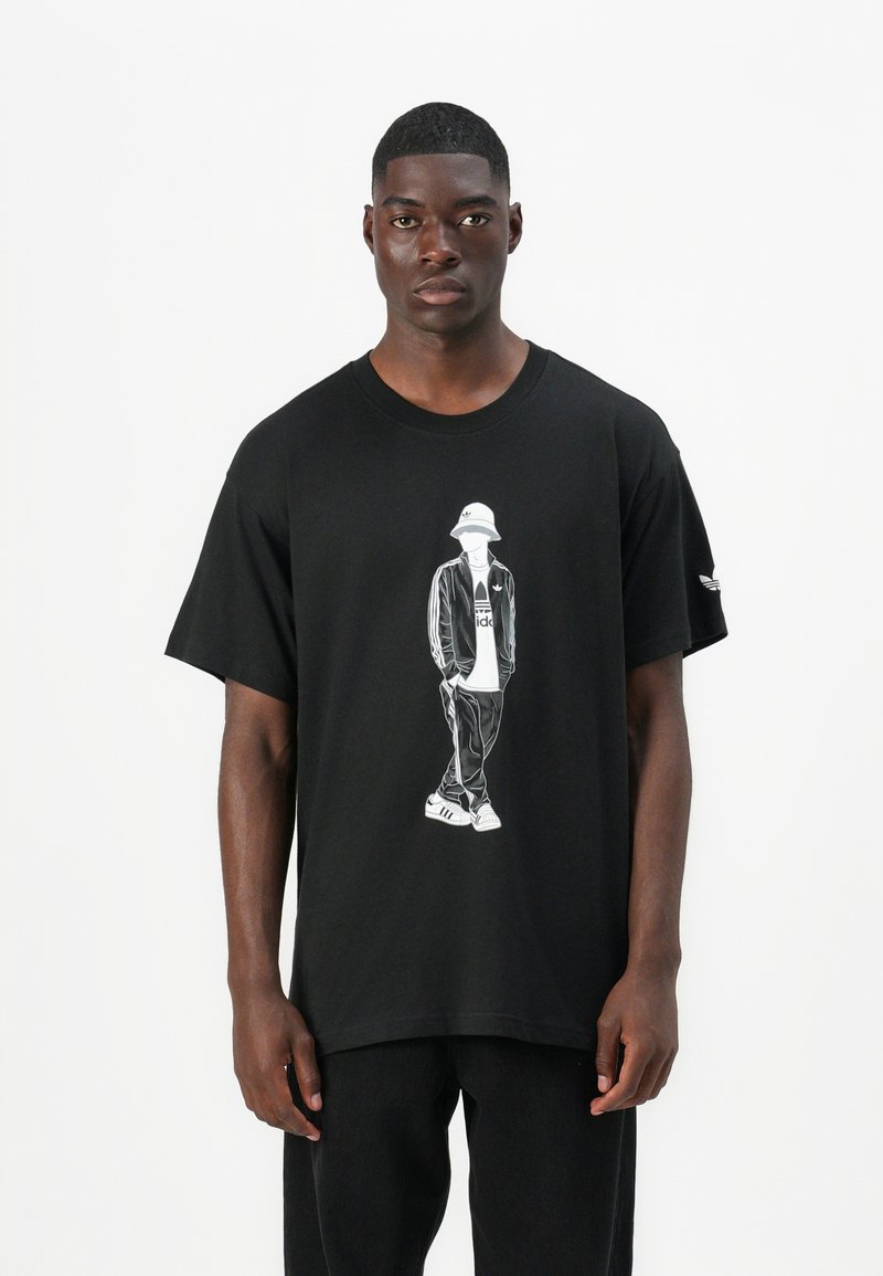 Μαύρη μπλούζα με κοντό μανίκι που διαθέτει λευκό γραφικό απεικόνισης ενός ατόμου με καπέλο και αθλητικά ρούχα. Διαθέτει στρογγυλή λαιμόκοψη και είναι φτιαγμένη από βαμβακερό υλικό.