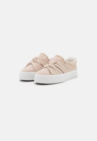 Canvas slip-on shoes in light pink with a knotted front detail and a white rubber sole. Smooth texture with a polka dot inner lining.