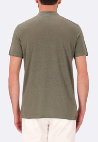 T-shirt verde oliva a maniche corte realizzato in tessuto morbido e strutturato. Collo rotondo semplice con orlo dritto, mostrato dal retro.