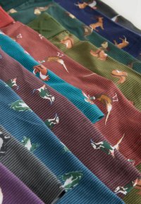 Riveittäin järjestettyjä värikkäitä resorikankaita, joissa toistuu erilaisia metsäeläinhahmoja, kuten peuroja, oravia, lintuja ja sammakoita.