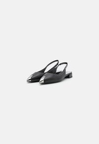 Melnas ādas slingback kurpes ar norādītām purngalām, sudraba metāliskiem akcentiem uz galiem un maziem piespraužamiem dekorācijas vienādas gar sāni.