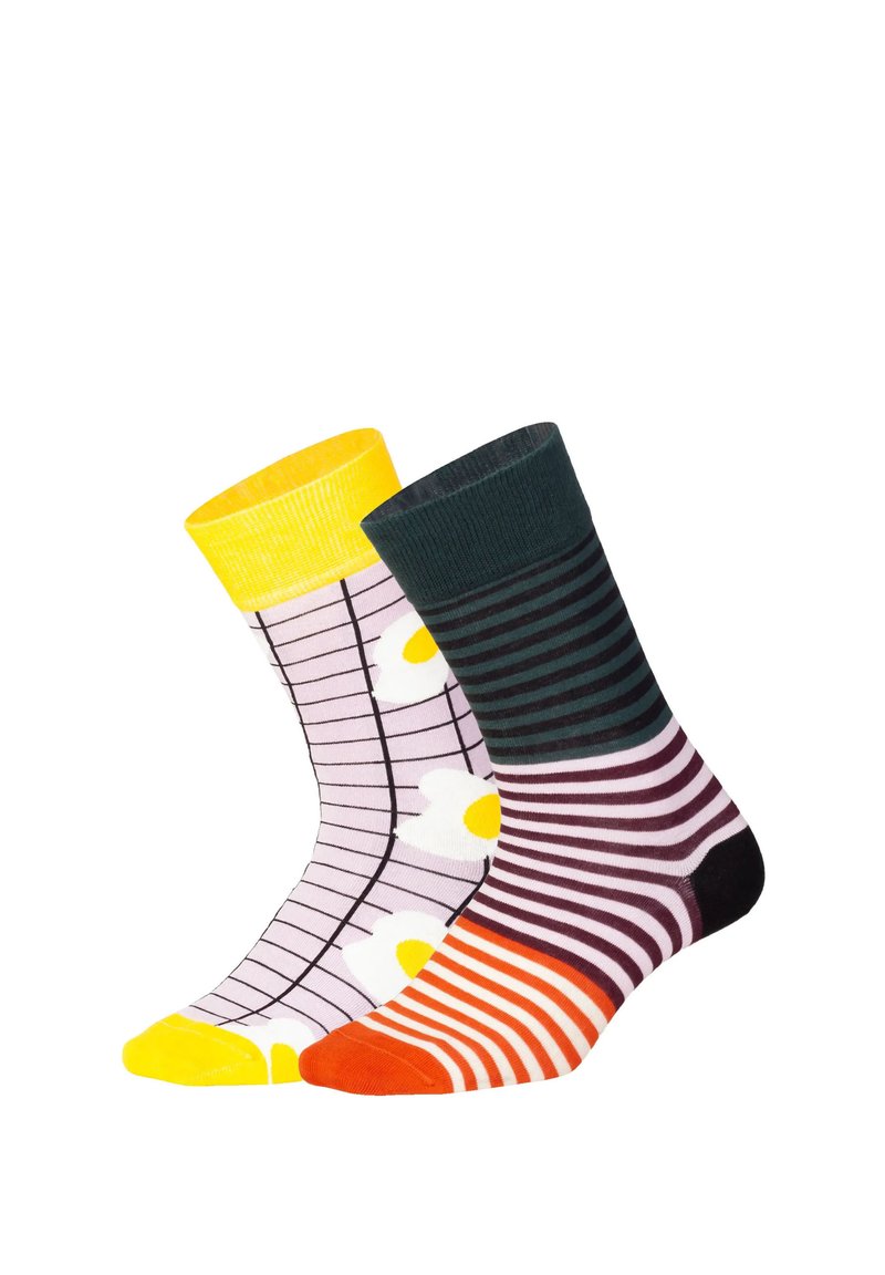 Dos pares de calcetines: uno púrpura con un patrón de cuadrícula y acentos amarillos, el otro verde oscuro con rayas y un dedo del pie naranja.